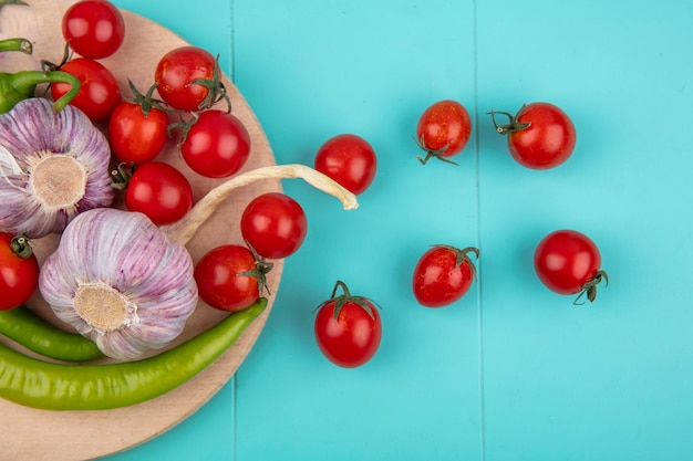 Free Photo top view of vegetables as garlic pepper tomato on cutting board on blue surface