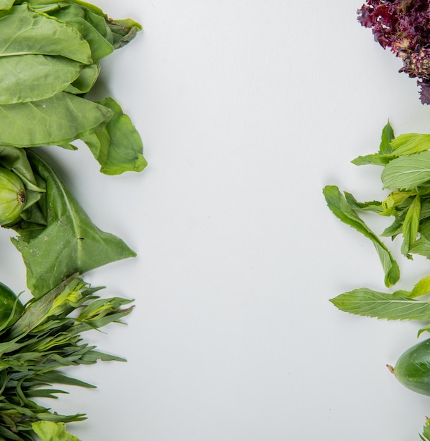 Top view of vegetables as spinach mint basil cucumber on white surface with copy space