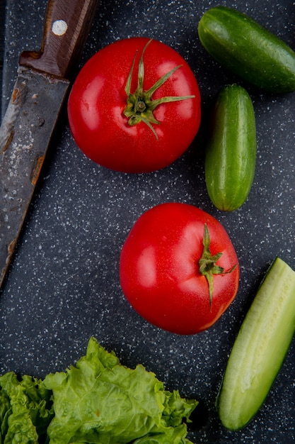 Free photo top view of vegetables as tomato cucumber lettuce with knife on cutting board as surface