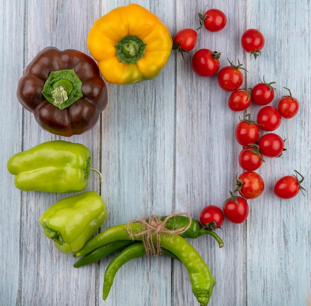 Top view of vegetables as tomato and pepper set in round shape on wooden surface