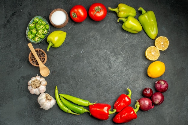 Free Photo top view vegetables composition tomatoes bell-peppers and garlics on dark background