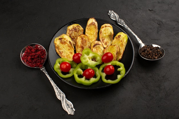 top view vegetables cooked and sliced fresh inside black plate on the dark