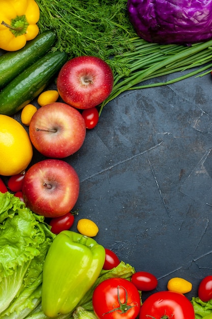 Top view vegetables and fruits cherry tomatoes cumcuat apples cucumbers red cabbage bell pepper free space