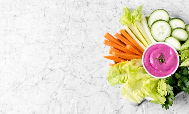 Top view of vegetables and pink sauce on plate with copy space