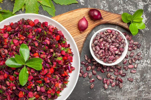 Top view vinaigrette salad with beet and beans on the grey surface