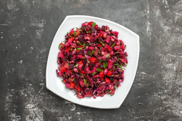 Top view vinaigrette salad with beets and beans on grey surface