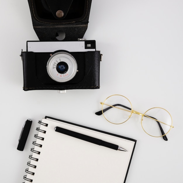 Free photo top view vintage photo camera with a notepad