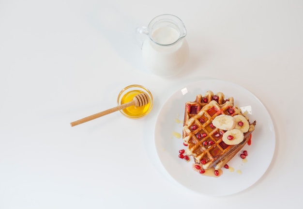 Free photo top view waffle with honey and milk