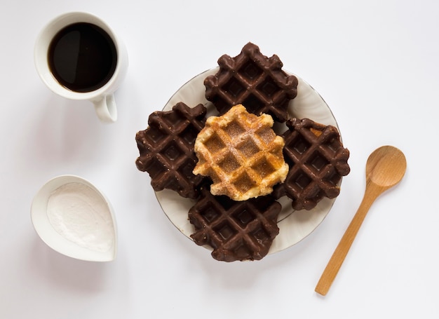 Top view of waffles on plate with coffee and spoon