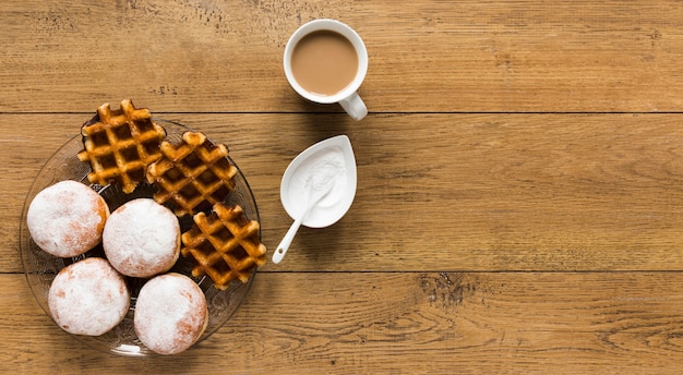 Top view of waffles with donuts and coffee