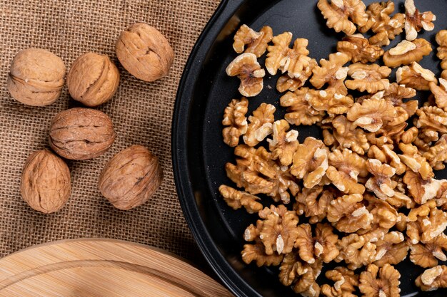 Top view walnuts on black pan on sackcloth  horizontal