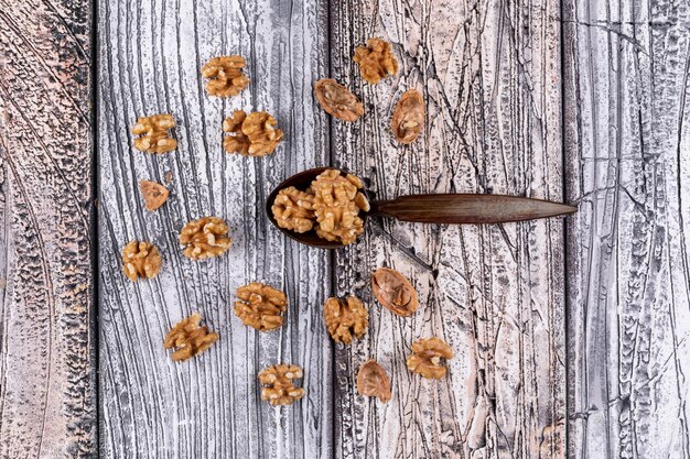 Top view walnuts and wooden spoon on wooden  horizontal