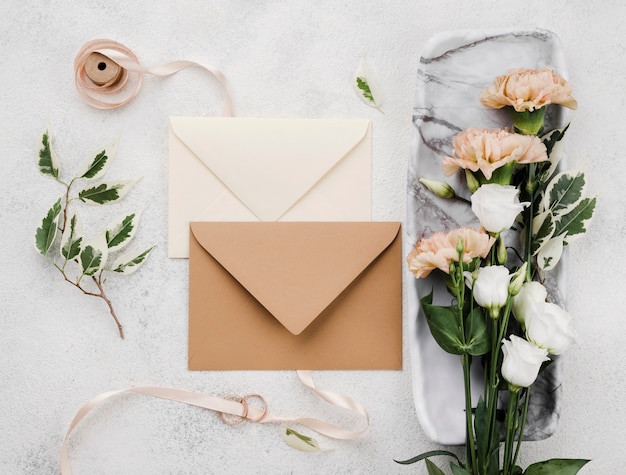 Free photo top view wedding invitation envelopes with flowers