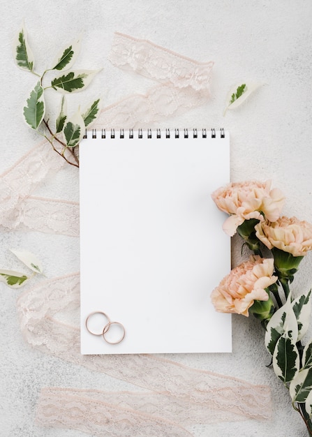 Free photo top view wedding rings with flowers on the table