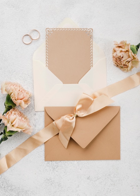 Top view wedding rings with ribbon and envelopes