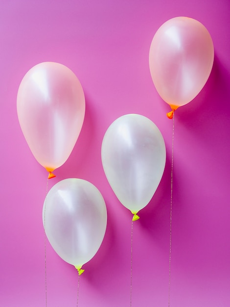 Free photo top view white balloons on pink background