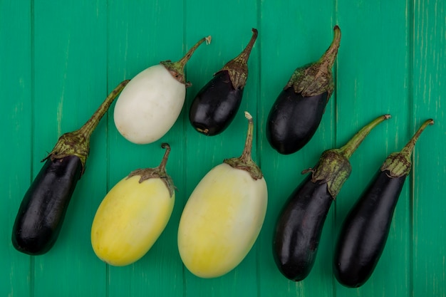 Free photo top view white and black eggplant on a green background