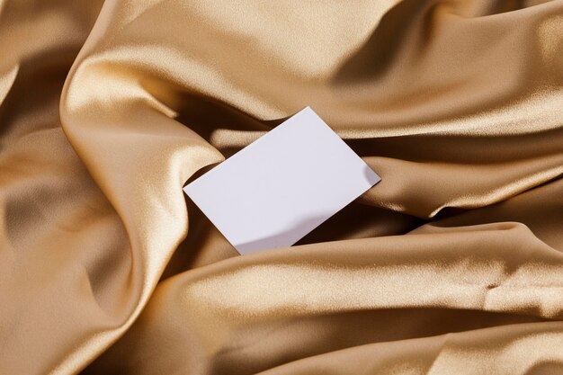 Top view white card on golden cloth