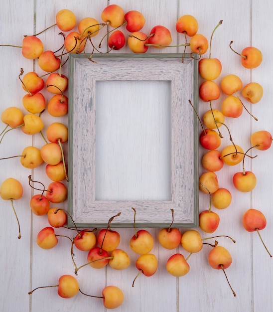 Free photo top view of white cherry with a frame on a white surface