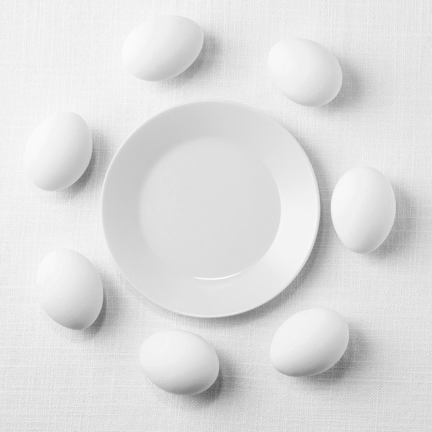 Top view white chicken eggs on table with plate