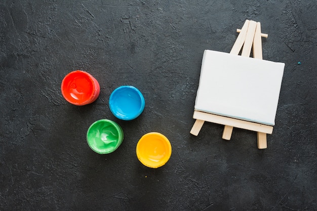 Free Photo top view of white miniature easel and small paint container