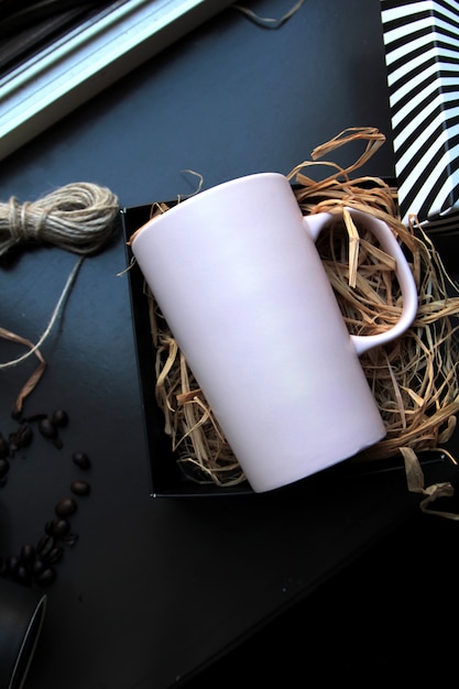 Top view white mug in a box on the hay