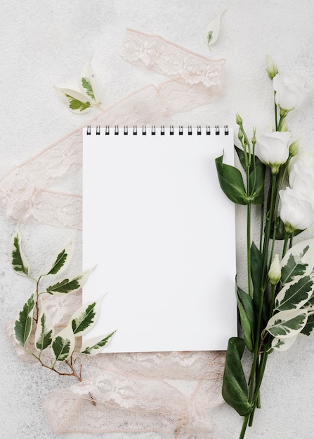 Free photo top view white notepad with flowers on the table