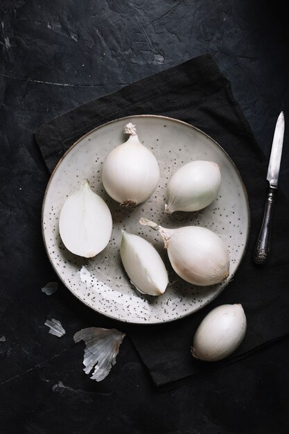 Top view white onions with a knife