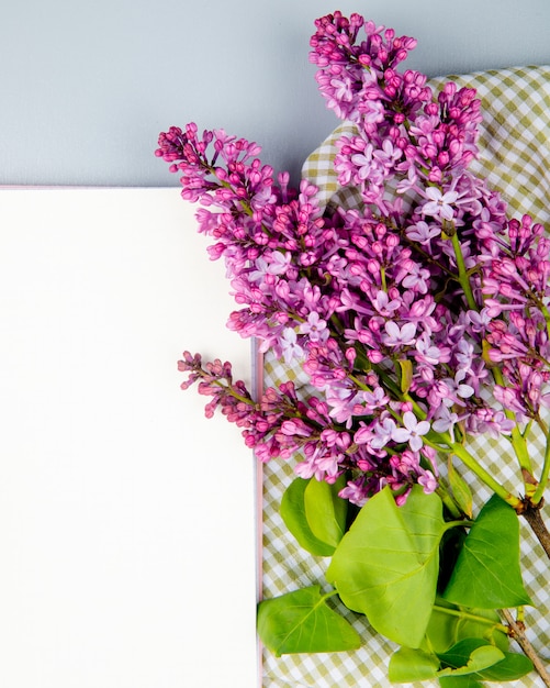 Free Photo top view of white paper sheets and lilac flowers on white background