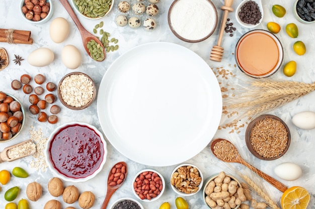 Top view white plate with jelly eggs different nuts and seeds on white dough sugar color biscuit cake sweet nut photo