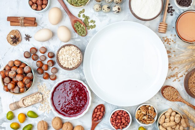 Top view white plate with jelly eggs different nuts and seeds on white dough sugar color biscuit sweet nut photo