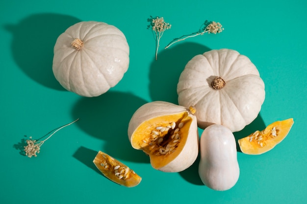 Free photo top view white pumpkins on green background