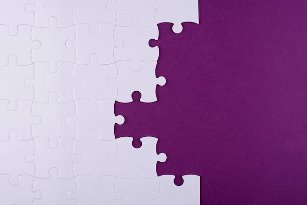 Free photo top view white puzzle pieces and purple background