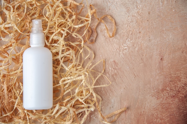 Free photo top view white spray bottle on nude background