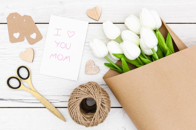 Top view of white tulips on wooden table