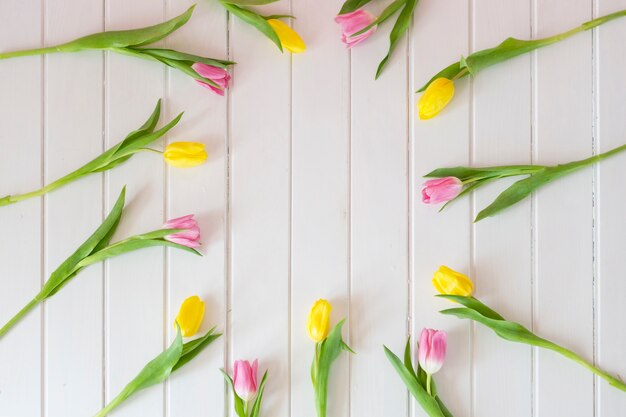 Top view of white wooden boards with floral frame