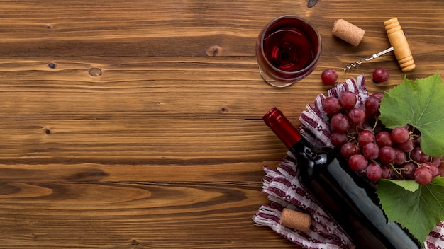 Top view wine bottle with glass on wooden background