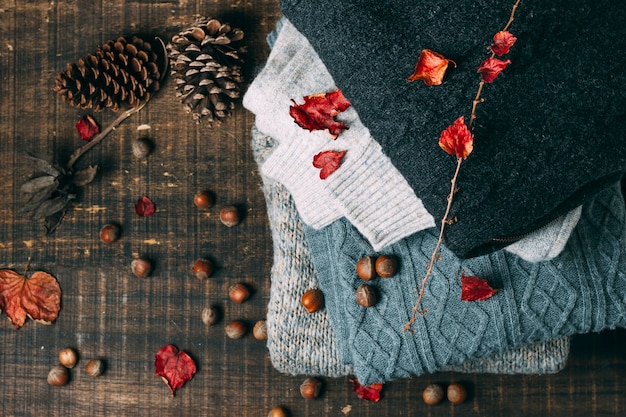 Free photo top view winter sweaters with pine cones