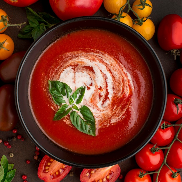 Top view of winter tomato soup in bowl with tomatoes