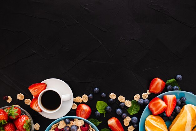 Top view with copy space on top of healthy breakfast on black wooden background