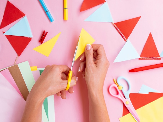 Free photo top view of woman cutting colored paper