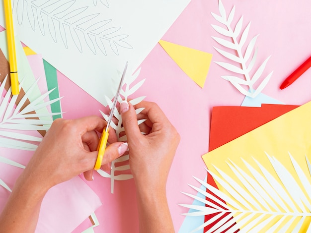 Top view of woman cutting paper tree branches