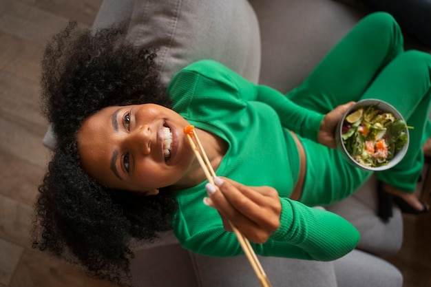 Top view woman eating salmon bowl