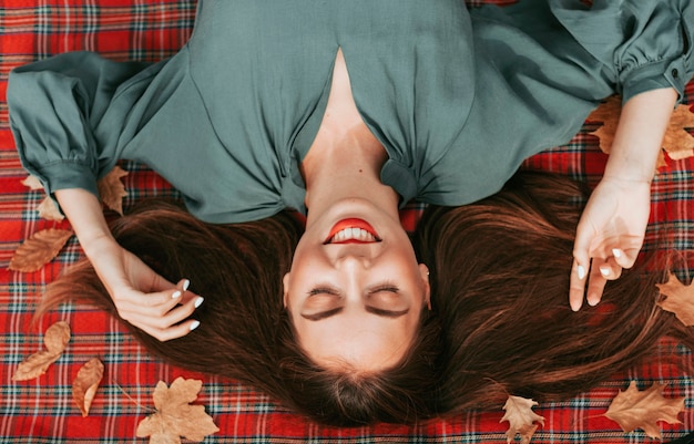 Free photo top view woman enjoying autumn on a picnic blanket