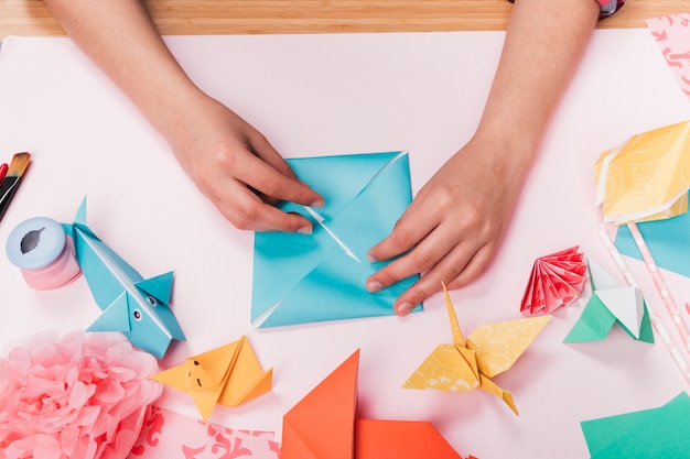 Free photo top view of woman hand making origami craft over table