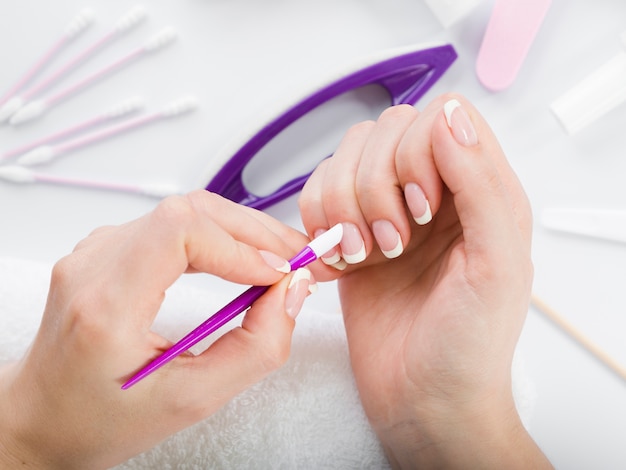 Free photo top view woman hands using manicure tools