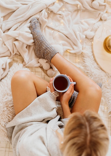 Top view woman holding a cup of tea while enjoying the winter holidays