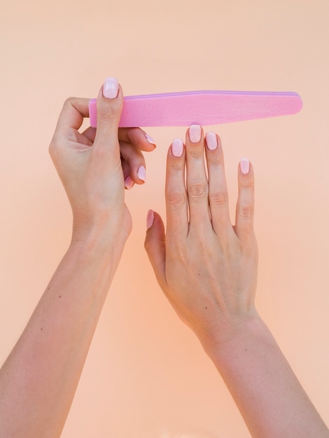 Free photo top view woman's hands using nail file