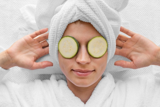 Top view woman wearing cucumber slices