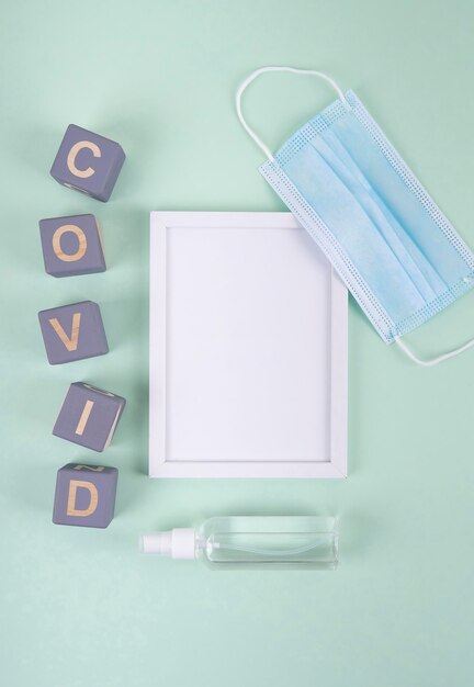 Top view of wooden cubes with covid and frame next to medical mask